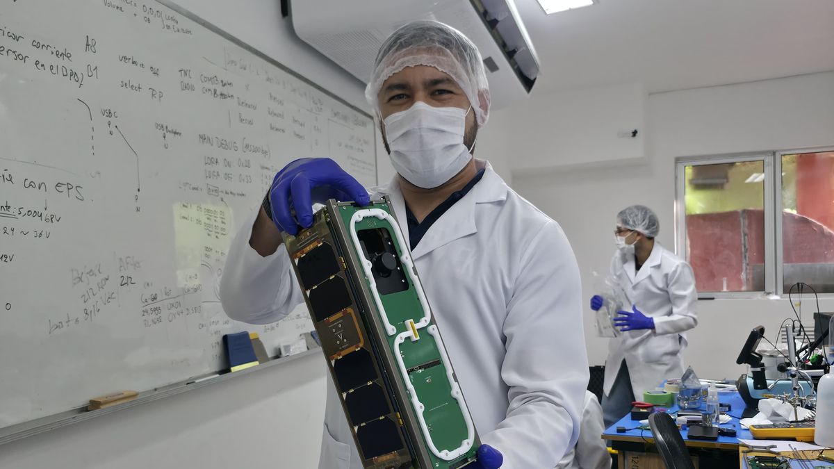 Federico Gaona sostiene el GuaraníSat-2 en el laboratorio de integración